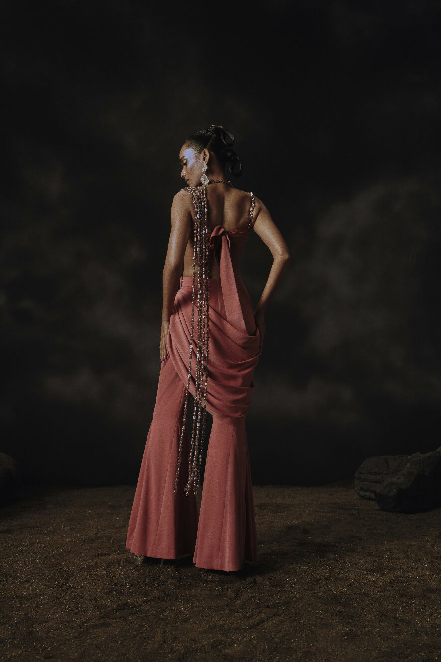 Woman in a long, elegant dress with a dark, textured background