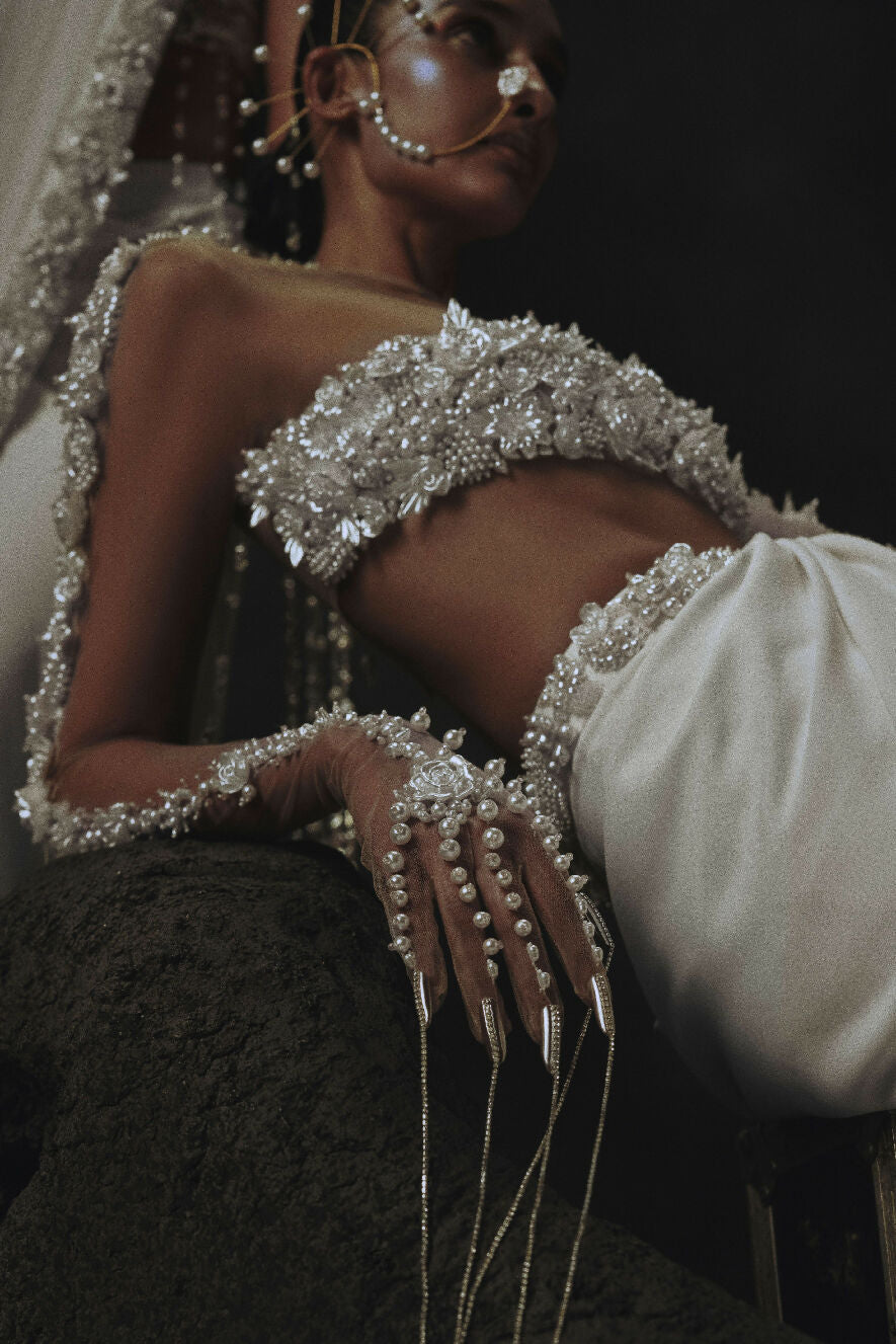 Woman wearing a sparkling silver outfit with a dark background