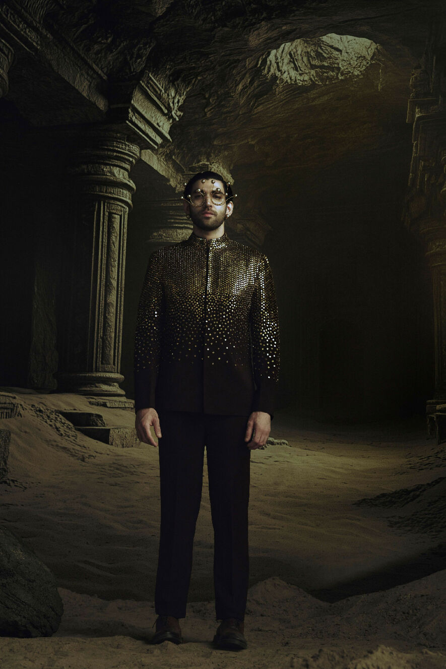 Man in a dark, ornate room with stone architecture