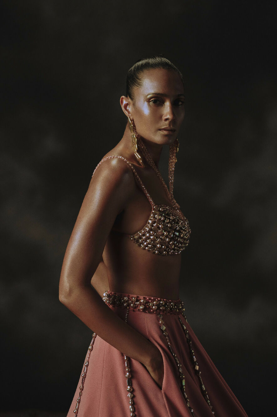 Model wearing a detailed dress with a dark background