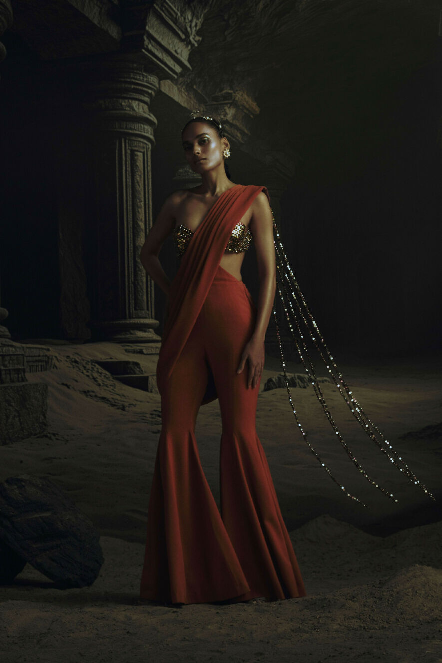Woman in a red saree with a dark, ancient ruin setting