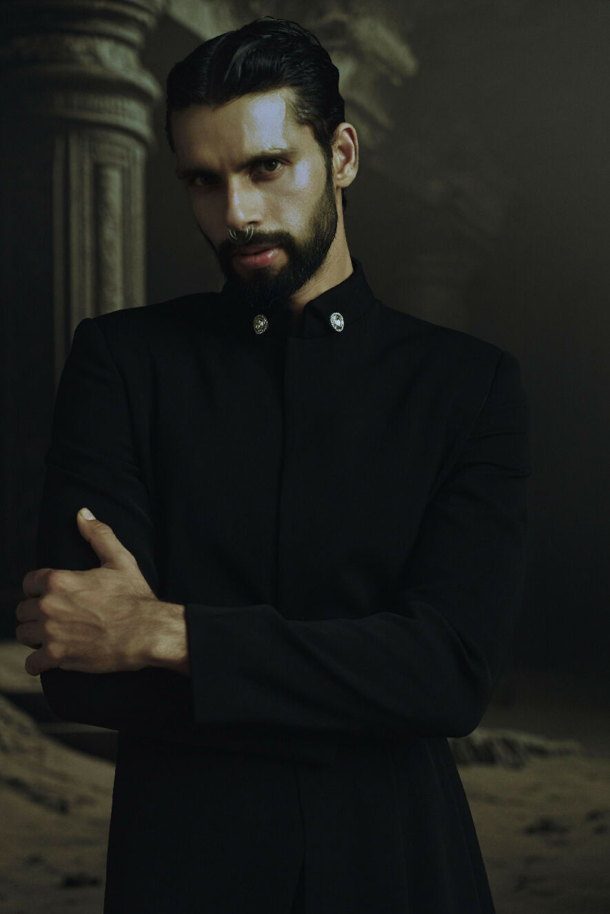 Man in a black coat with a dark background