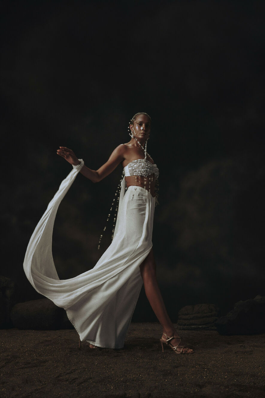 Woman in a flowing white dress with a dark background